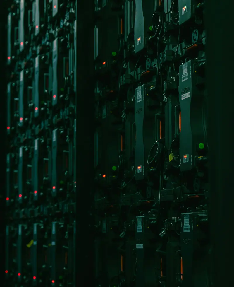 Dark server rack with glowing red and green LEDs, representing data centers, cloud computing, cybersecurity, or IT infrastructure.